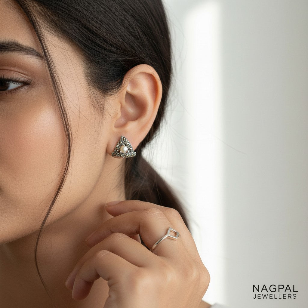NAGPAL JEWELLERS The Pearl Delta triangular earrings with pearl center and marcasite accents, made of 92.5 silver.
