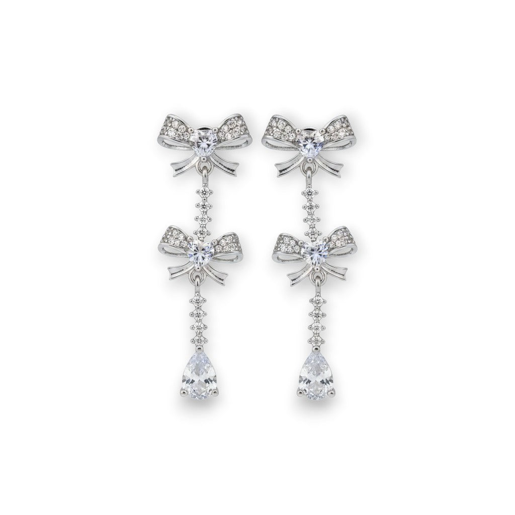 NAGPAL JEWELLERS Dual-Ton Love Studs, silver bow earrings with clear cubic zirconia teardrop pendant.