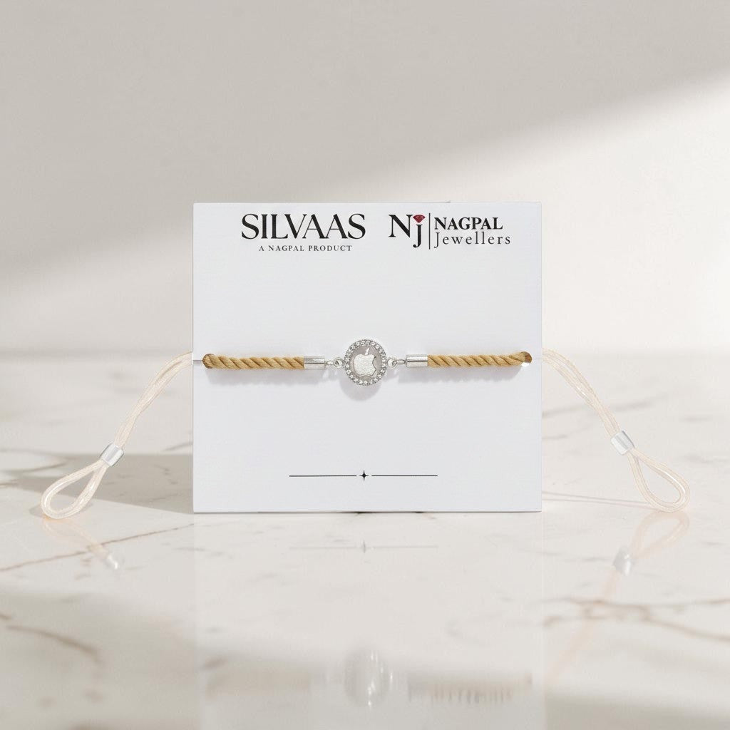 SILVAAS premium silver apple logo Rakhi featuring a stone-encrusted halo on a beige cord, presented on display card.