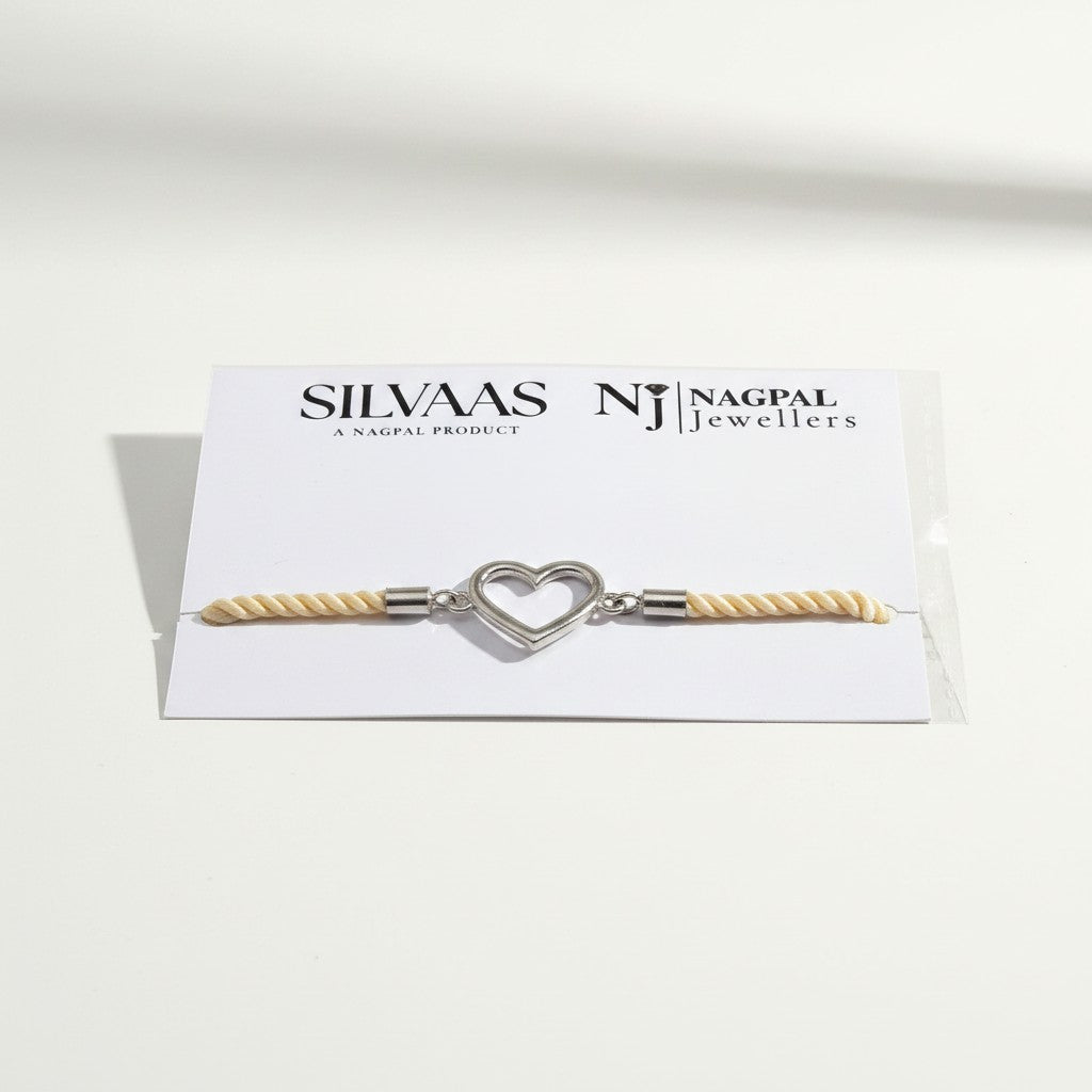 SILVAAS silver heart charm bracelet with cream twisted rope cord on a branded display card