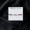 SILVAAS premium silver BRO Jaguar car logo rakhi with blue and gold braided thread on a white display card.