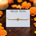 SILVAS premium silver Hanuman Ji Rakhi with gold-tone finish and stone accents on a white display card