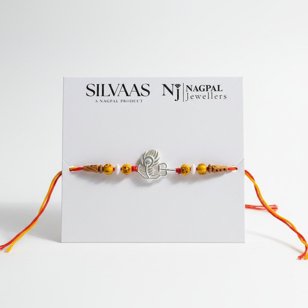 SILVAS peacock feather design silver rakhi bracelet with yellow patterned beads and red thread on a display card