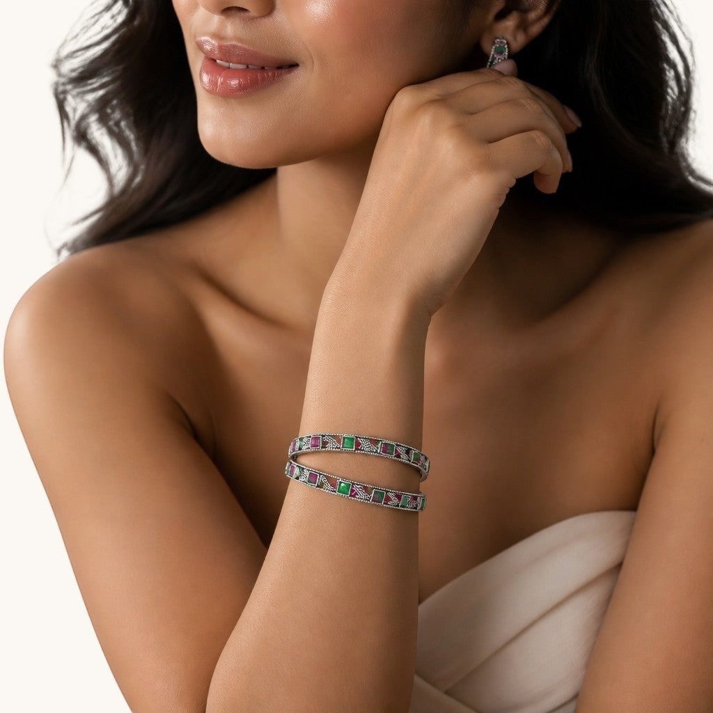 SILVAS silver bangle bracelets featuring square-cut red and green gemstones worn on a woman's wrist