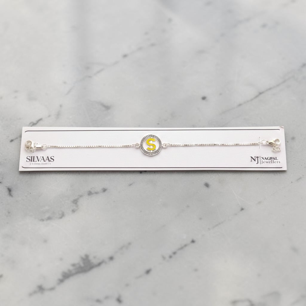 SILVAS 92.5 sterling silver bracelet featuring a circular charm with a yellow letter S on a white marble background